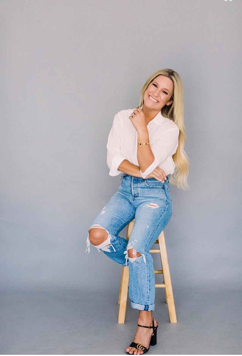 Eroe founder in white blouse, sweat-free with patented bra, smiling, stylish, confident.
